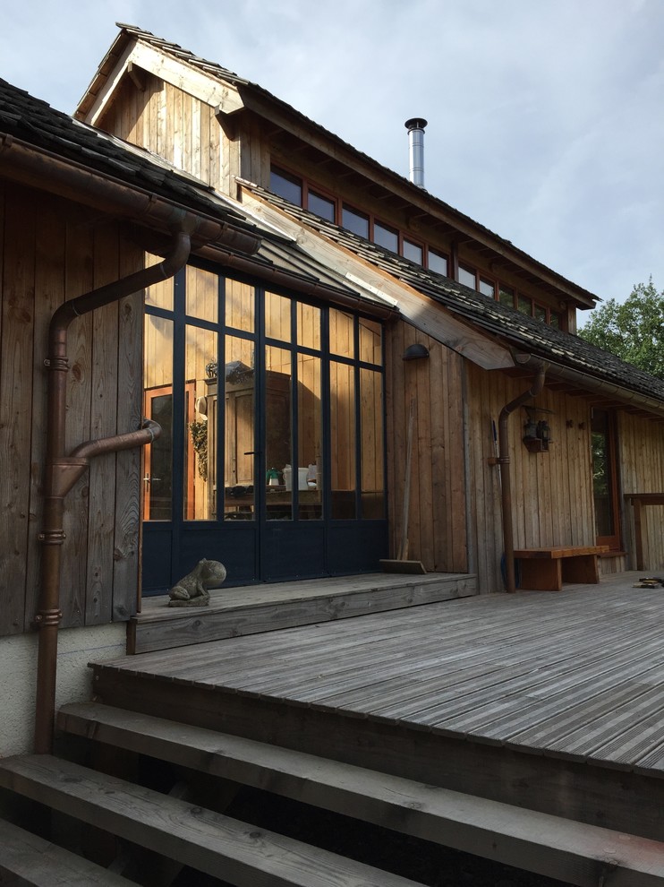 Modelo de galería de estilo de casa de campo extra grande sin chimenea con suelo de madera oscura, techo de vidrio y suelo gris