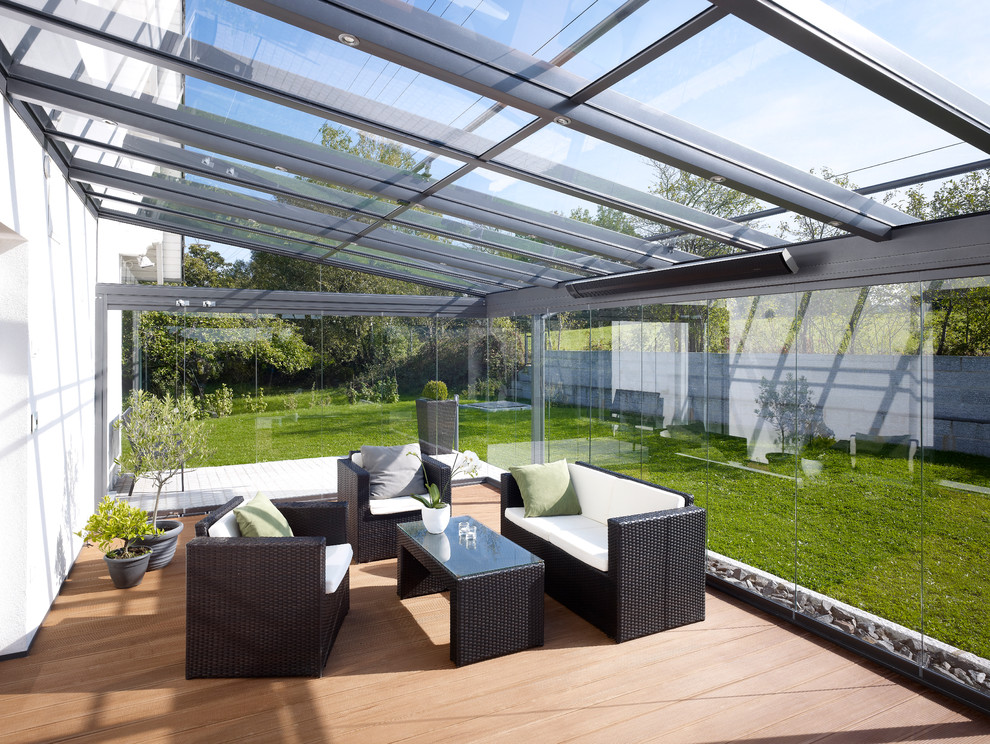 Photo of a large contemporary conservatory in Strasbourg with a glass ceiling, light hardwood flooring and no fireplace.