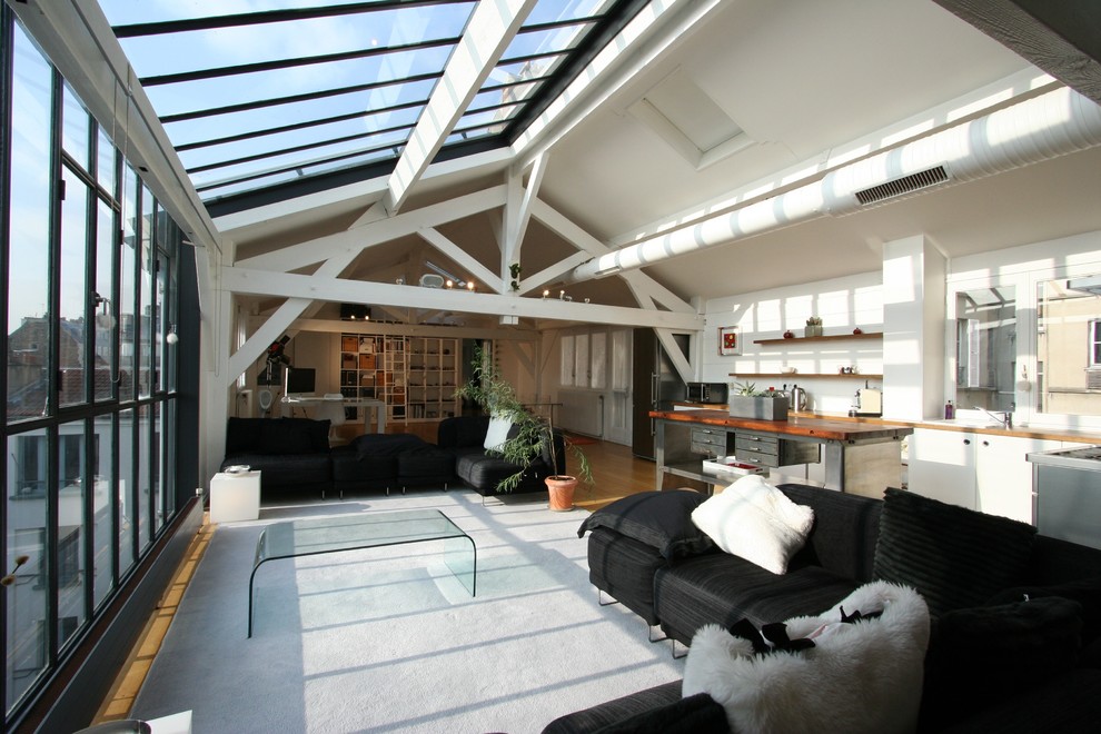 Large contemporary conservatory in Paris with medium hardwood flooring and a skylight.