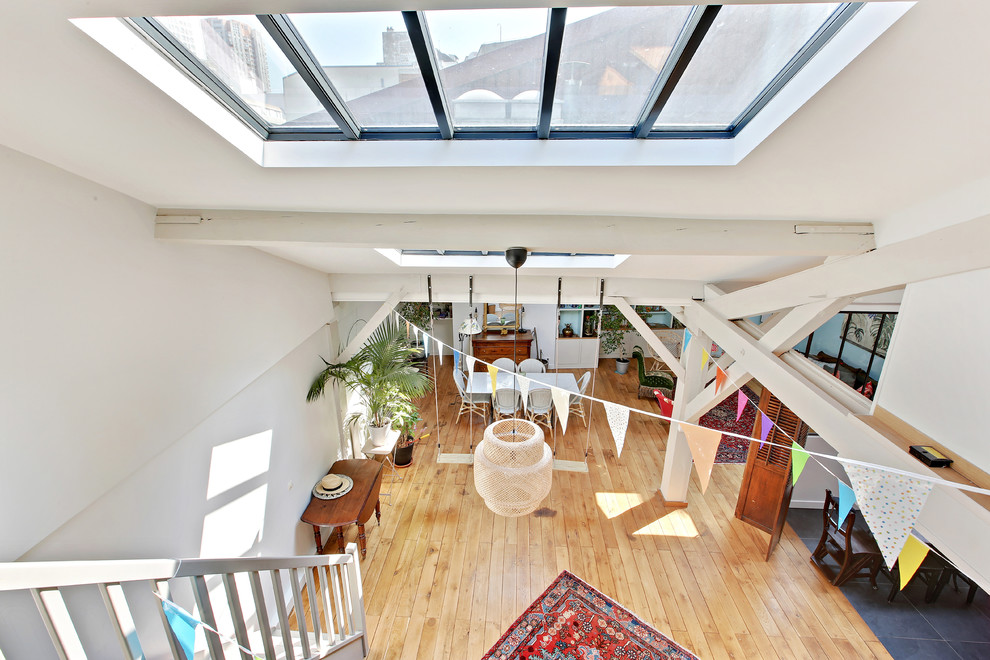 Esempio di una grande veranda tropicale con pavimento in legno massello medio, soffitto in vetro e pavimento marrone