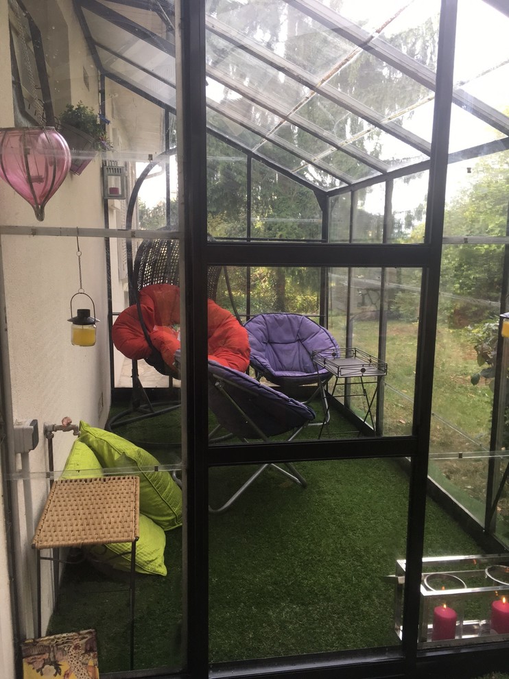 Idee per una veranda bohémian di medie dimensioni con moquette, soffitto in vetro e pavimento verde