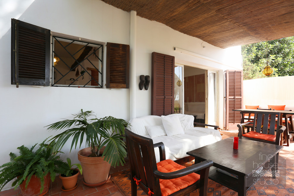 Diseño de porche cerrado mediterráneo grande en patio delantero con suelo de baldosas y toldo