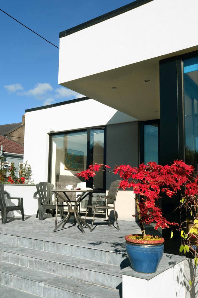Design ideas for a medium sized contemporary back veranda in Cork with natural stone paving.