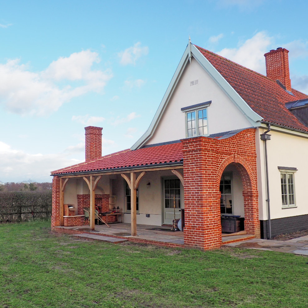 Exemple d'un porche d'entrée de maison latéral chic de taille moyenne avec des pavés en pierre naturelle et une extension de toiture.