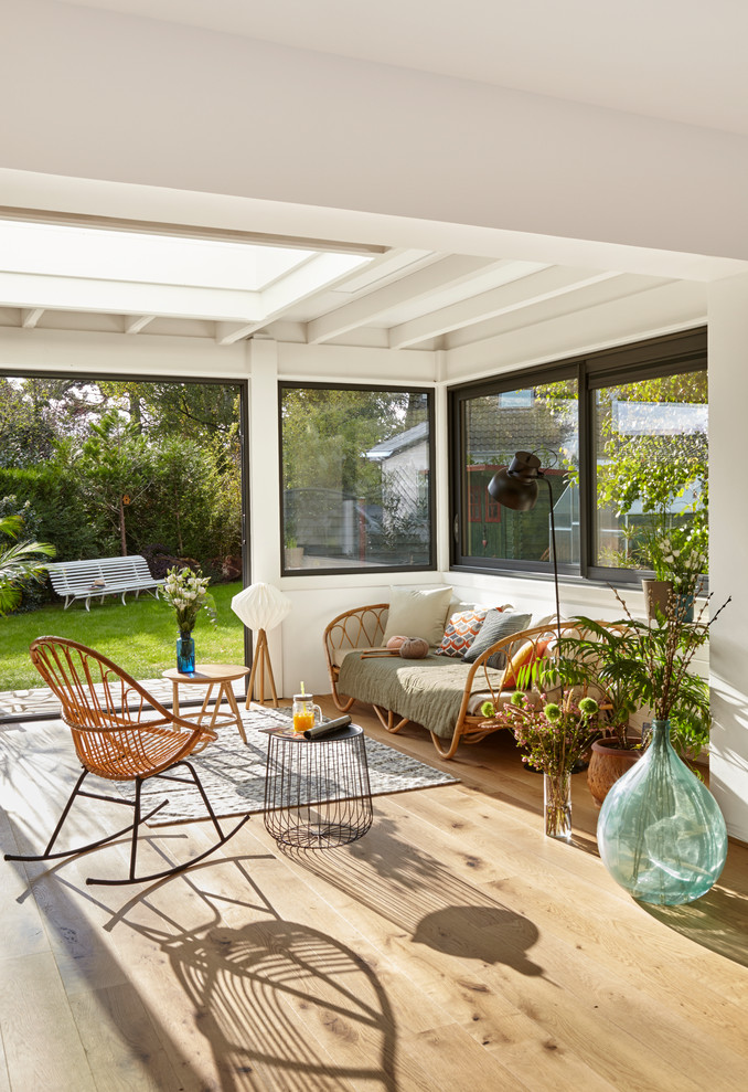Ispirazione per una veranda design con pavimento in legno massello medio, lucernario e pavimento marrone