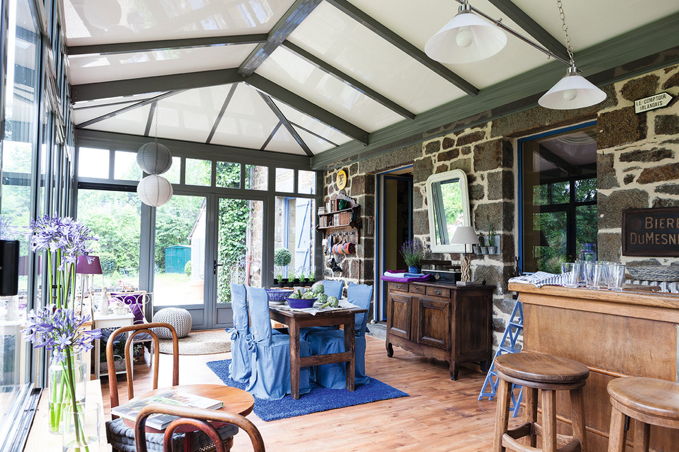 Idee per una veranda country con pavimento in legno massello medio e soffitto classico