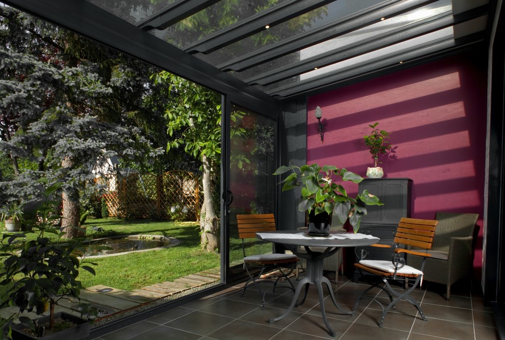 Foto di una veranda classica di medie dimensioni con soffitto in vetro, pavimento con piastrelle in ceramica e nessun camino
