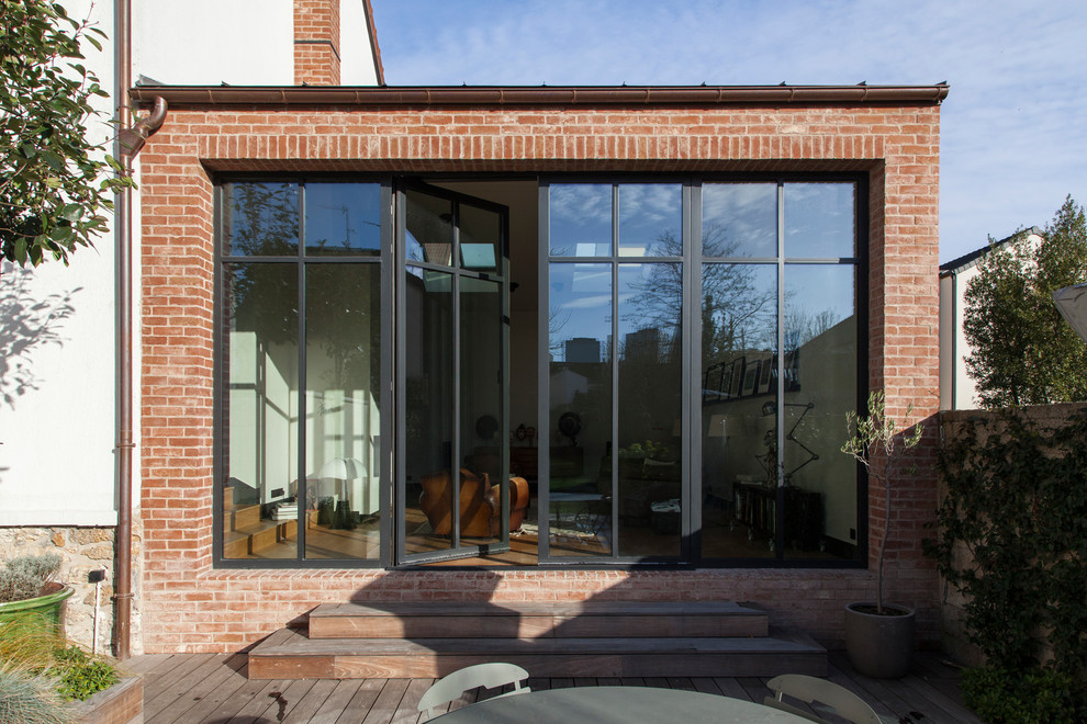 Idee per una veranda minimal di medie dimensioni con parquet chiaro, camino classico e cornice del camino in intonaco