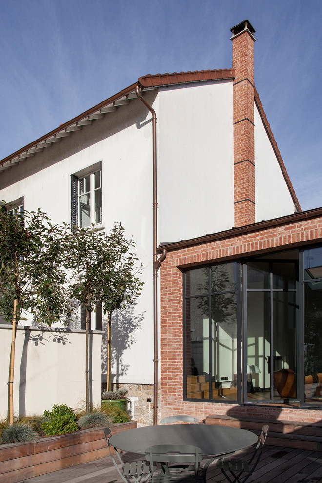 Foto di una veranda design di medie dimensioni con parquet chiaro, camino classico e cornice del camino in intonaco