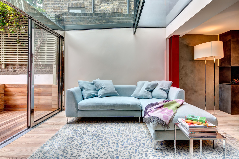 ロンドンにあるコンテンポラリースタイルのおしゃれなサンルーム (横長型暖炉、ガラス天井) の写真