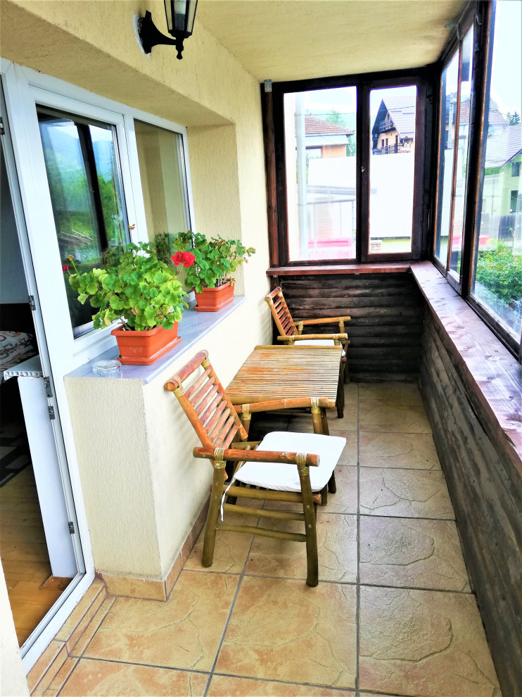 Esempio di un'ampia veranda stile rurale con parquet chiaro, soffitto classico e pavimento beige