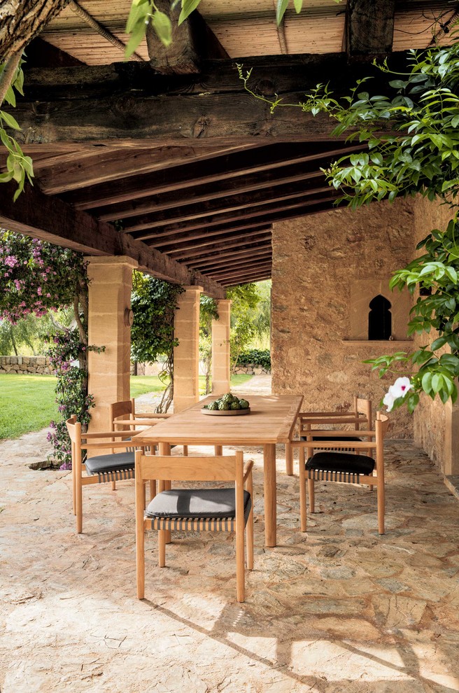 Immagine di un patio o portico mediterraneo di medie dimensioni e dietro casa con un tetto a sbalzo