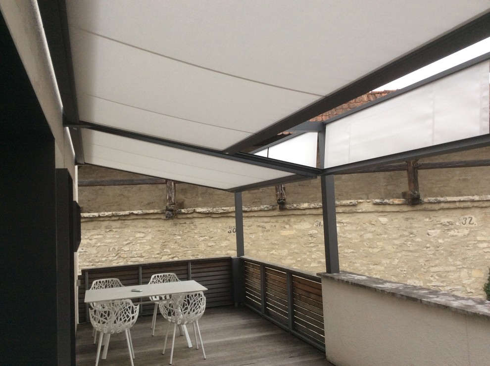 Immagine di un piccolo portico design dietro casa con pedane e un parasole
