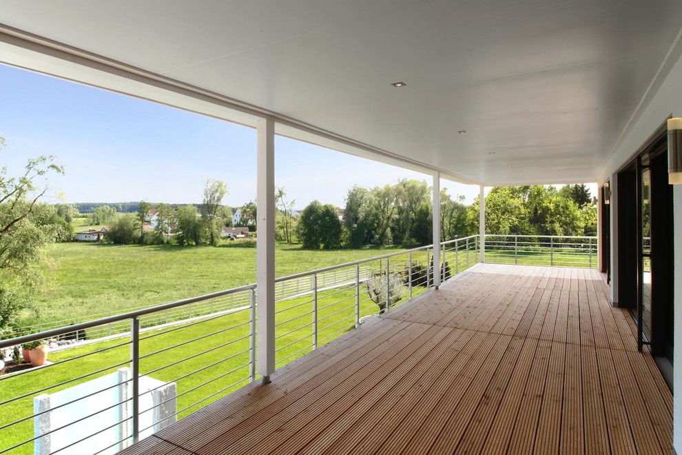 Réalisation d'un grand porche d'entrée de maison latéral design avec une moustiquaire, une terrasse en bois et une extension de toiture.