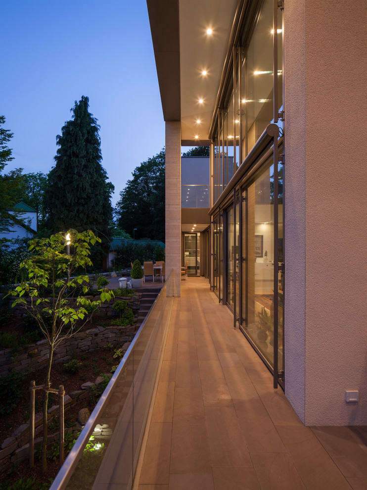 Exemple d'un grand porche d'entrée de maison avant tendance avec des pavés en pierre naturelle et une extension de toiture.