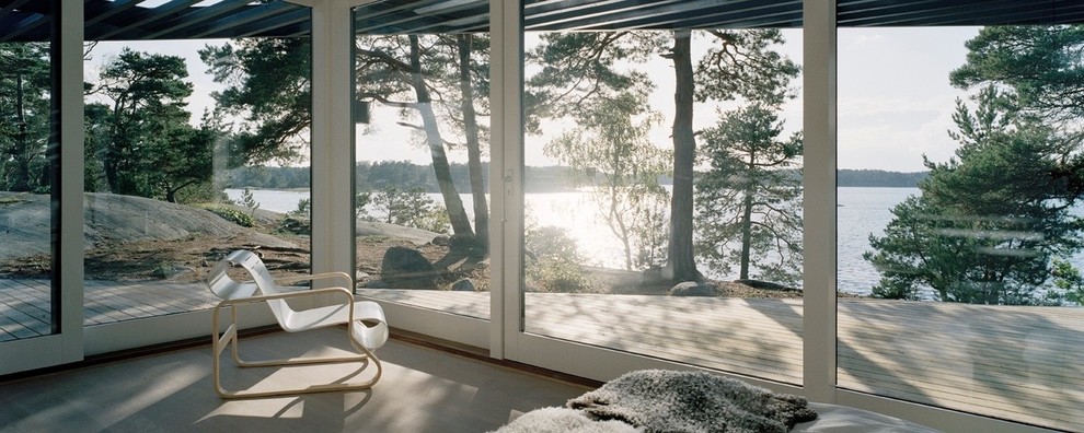 Cette photo montre un porche d'entrée de maison latéral scandinave de taille moyenne avec une terrasse en bois, une pergola et une moustiquaire.