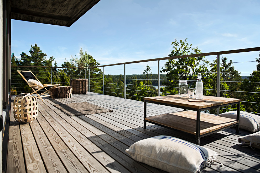 Idées déco pour un porche d'entrée de maison arrière scandinave de taille moyenne avec une terrasse en bois et une extension de toiture.