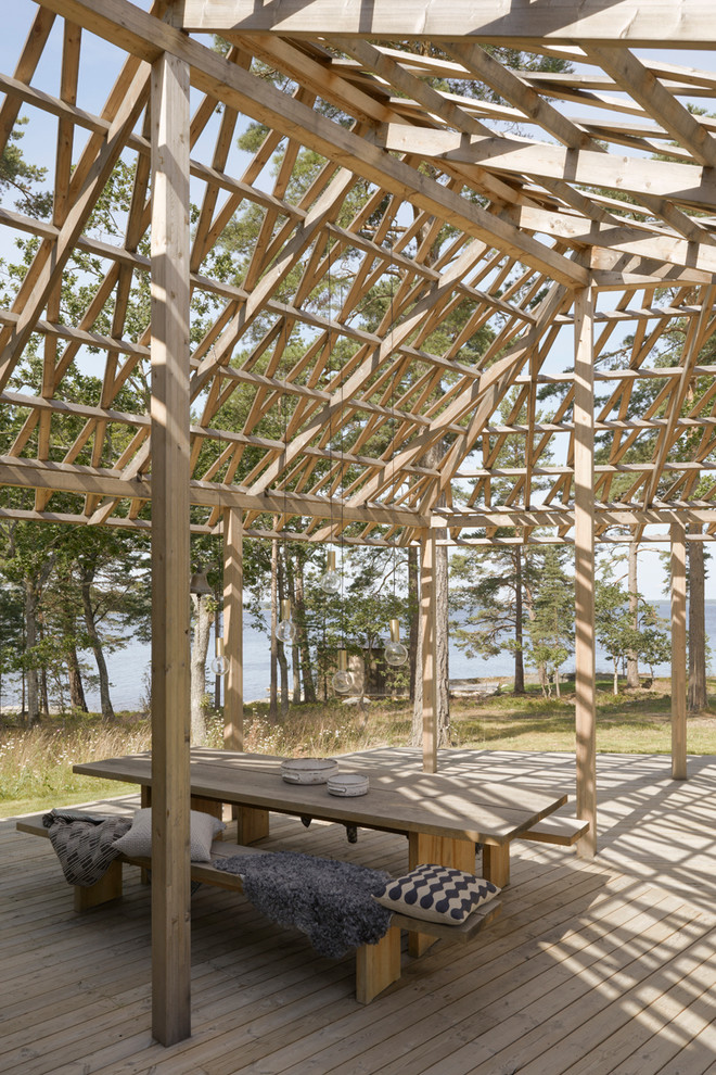 This is an example of a large scandi back veranda in Stockholm with decking and a pergola.