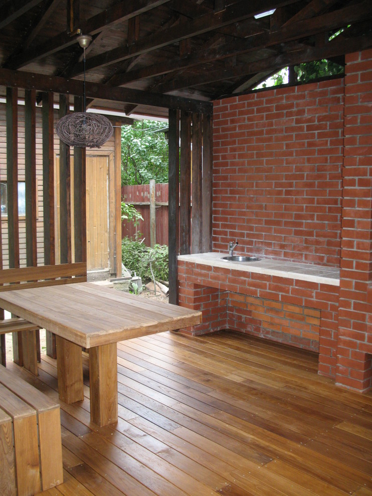 На фото: веранда среднего размера на переднем дворе в современном стиле с летней кухней, настилом и навесом
