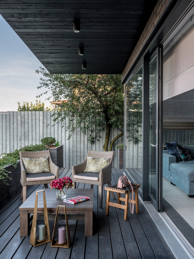 Diseño de terraza contemporánea en anexo de casas con entablado