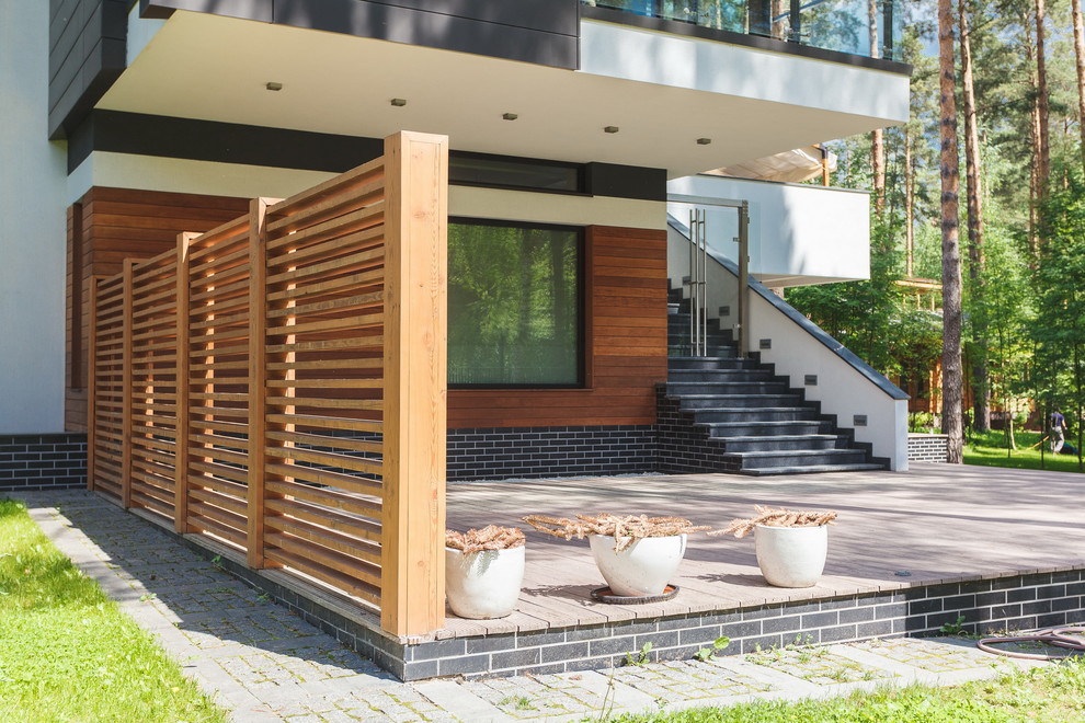 Aménagement d'un porche d'entrée de maison contemporain avec une terrasse en bois.