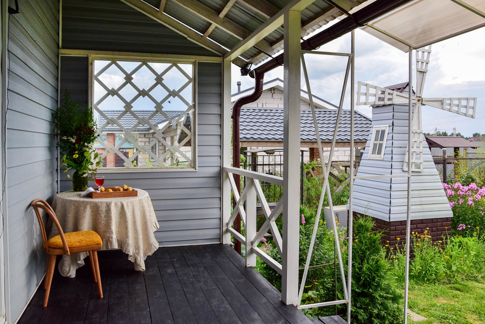Idée de décoration pour un porche d'entrée de maison arrière champêtre avec une extension de toiture et une terrasse en bois.