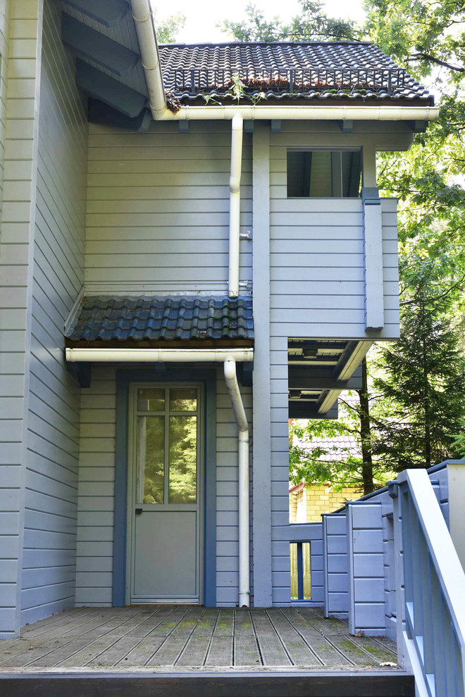 Esempio di un portico classico di medie dimensioni e nel cortile laterale con pavimentazioni in cemento e un tetto a sbalzo