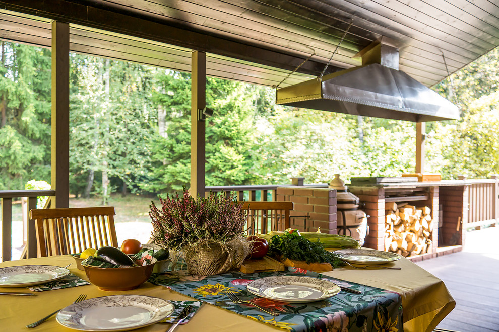 Idées déco pour un grand porche d'entrée de maison arrière campagne avec une cuisine d'été et une extension de toiture.