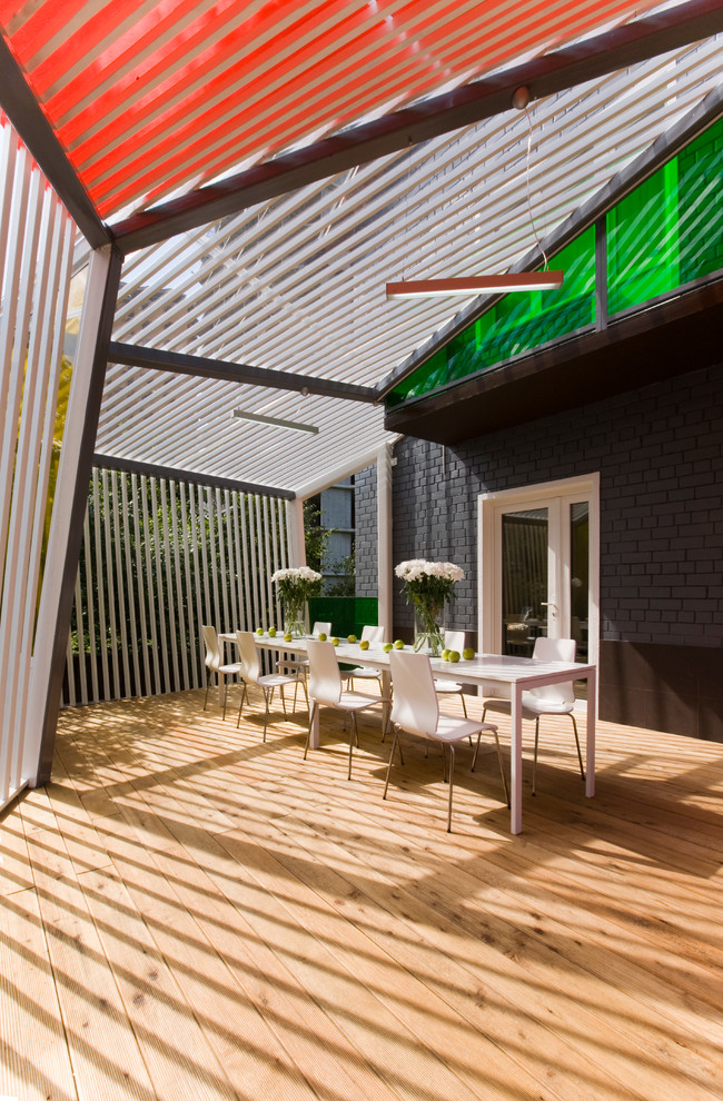 Immagine di un portico design dietro casa e di medie dimensioni con un tetto a sbalzo