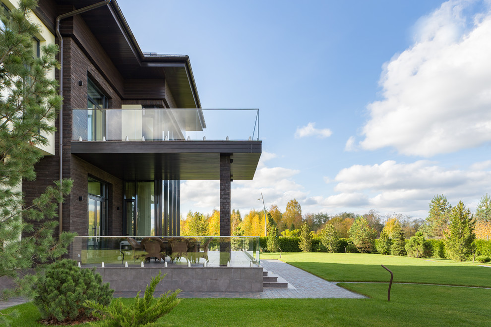 Inspiration pour un grand porche d'entrée de maison arrière design avec une cuisine d'été, du carrelage, un auvent et un garde-corps en verre.