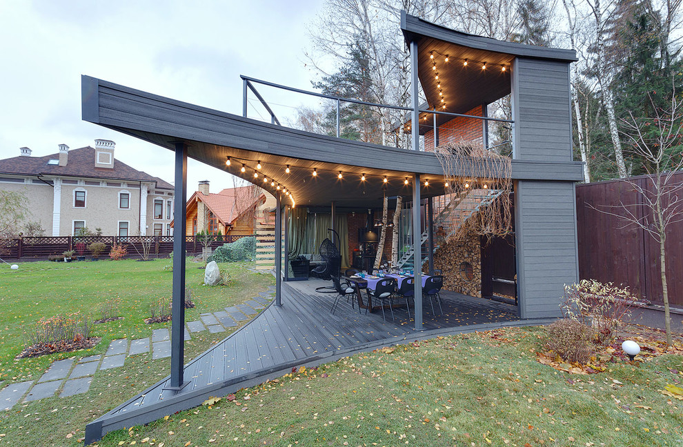 Exempel på en modern veranda, med trädäck och takförlängning