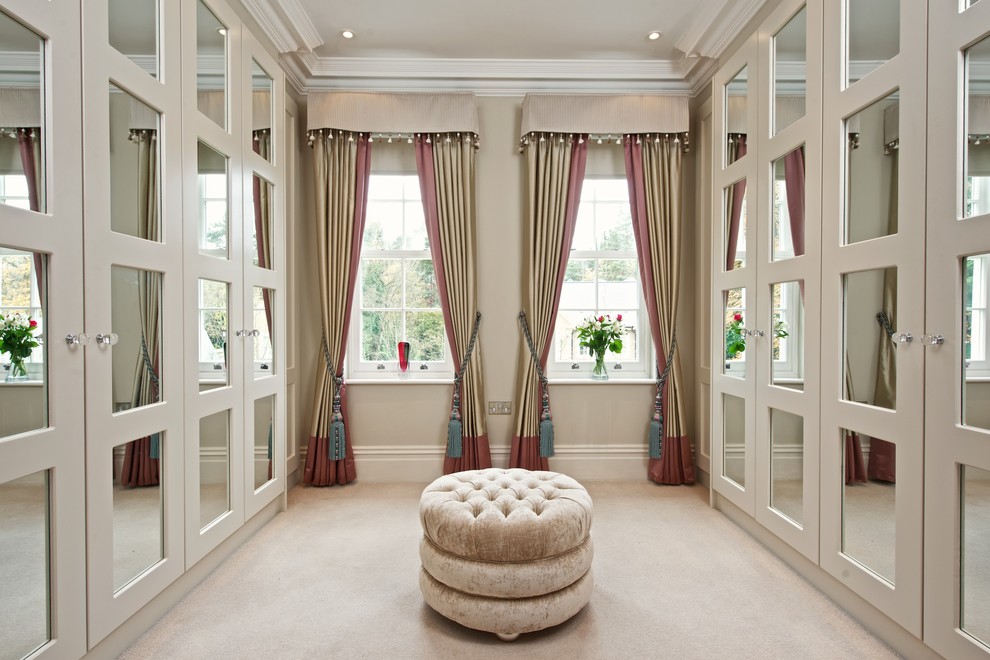Large transitional women's carpeted and beige floor dressing room photo in London with recessed-panel cabinets and beige cabinets