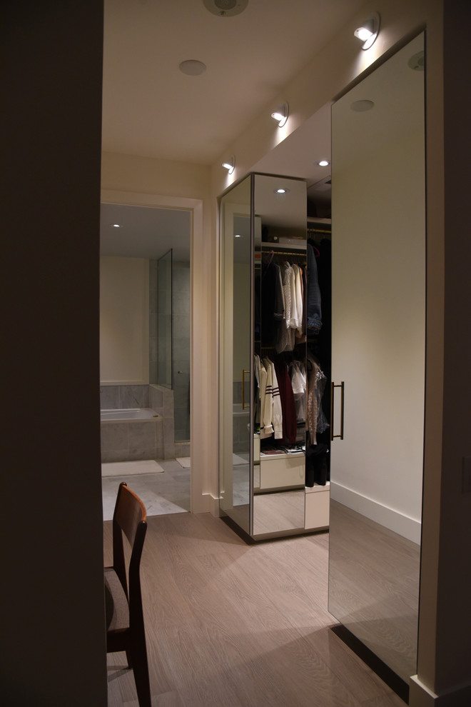Ejemplo de armario vestidor de mujer contemporáneo de tamaño medio con suelo de madera clara y suelo gris