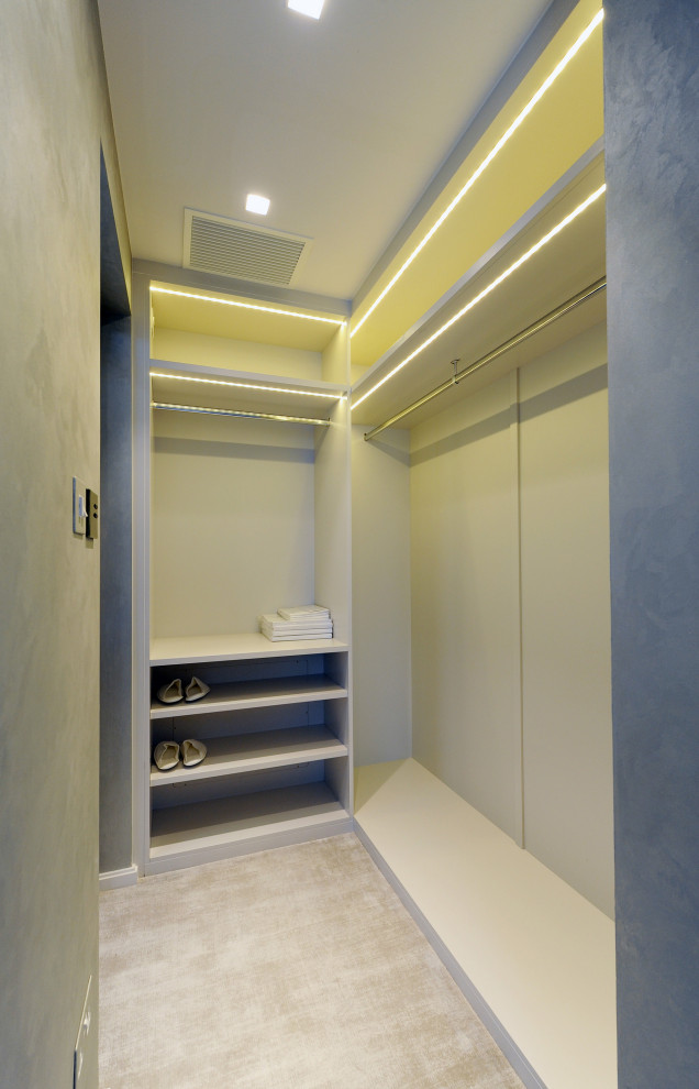 Foto di una piccola cabina armadio unisex minimal con moquette e pavimento beige