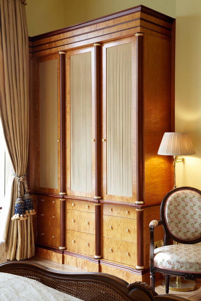 Diseño de armario y vestidor clásico grande con suelo de madera clara