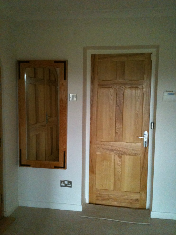 Imagen de vestidor unisex tradicional renovado de tamaño medio con armarios con paneles empotrados, puertas de armario de madera clara y moqueta