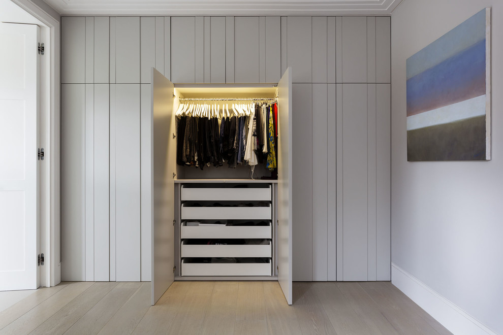 Идея дизайна: шкаф в нише унисекс в современном стиле с паркетным полом среднего тона