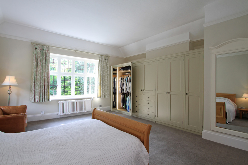 This is an example of a large classic wardrobe in Hampshire with carpet.