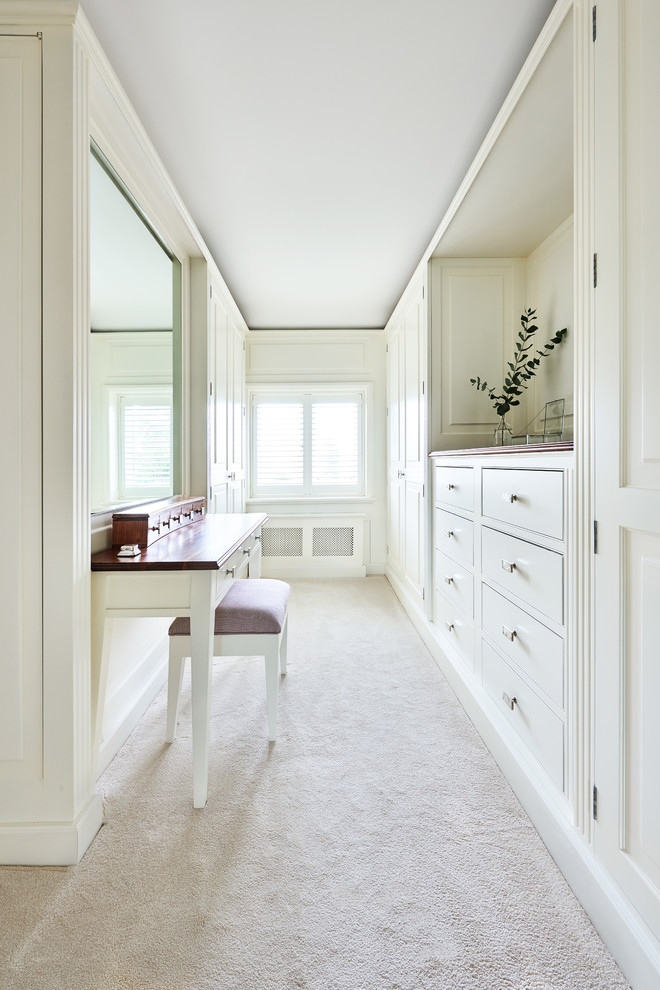 Aménagement d'un dressing room classique pour une femme avec des portes de placard blanches, moquette et un sol beige.