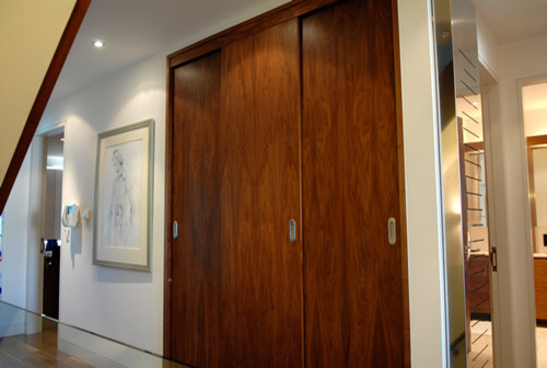 Idées déco pour un dressing et rangement contemporain en bois foncé de taille moyenne avec un placard à porte plane.