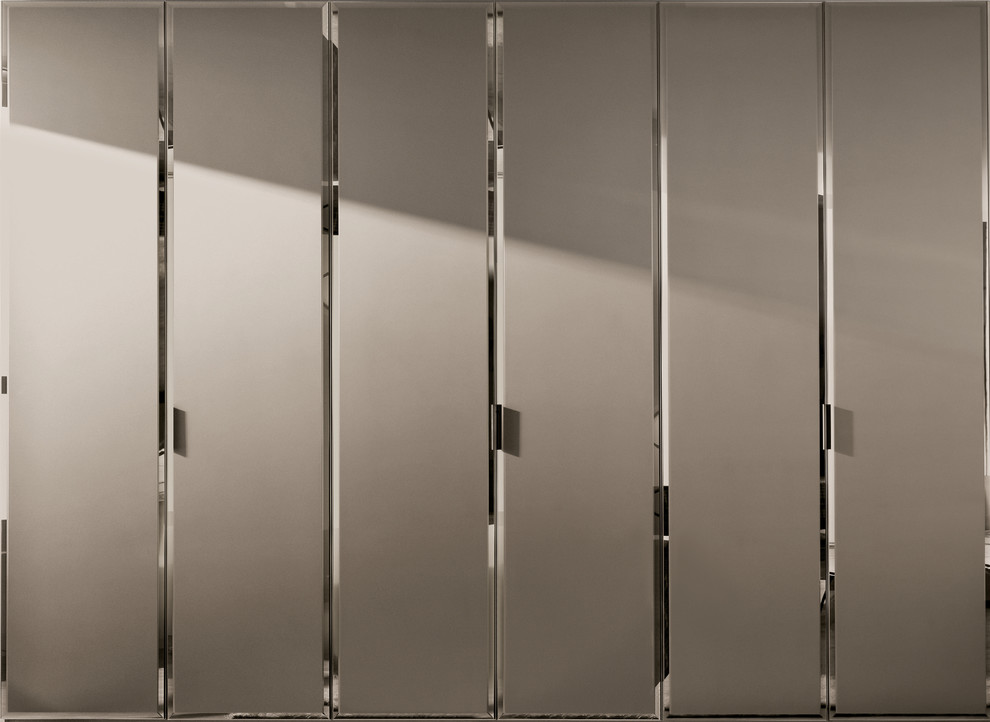 Esempio di uno spazio per vestirsi unisex minimal di medie dimensioni con ante di vetro, ante in legno scuro e pavimento in legno massello medio