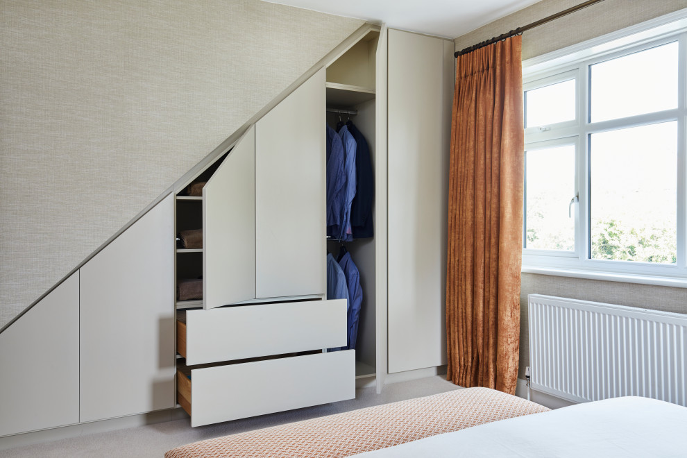 Imagen de armario tradicional renovado de tamaño medio con moqueta, armarios con paneles lisos, puertas de armario beige y suelo beige