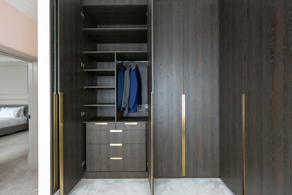 Imagen de armario vestidor contemporáneo de tamaño medio con armarios con paneles lisos, puertas de armario de madera en tonos medios, moqueta y suelo gris