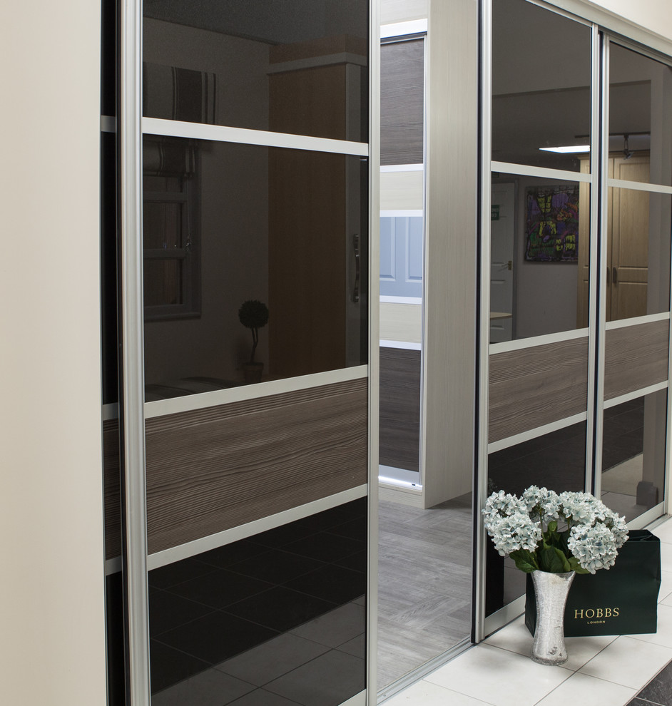 Example of a trendy gender-neutral closet design in Other with glass-front cabinets