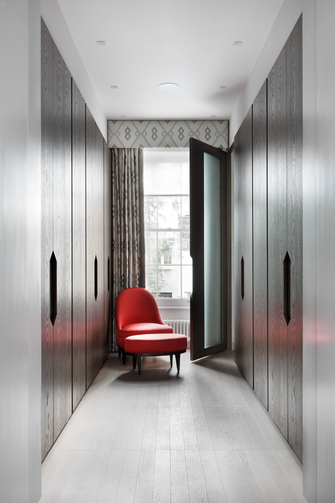 Neutrales, Mittelgroßes Modernes Ankleidezimmer mit flächenbündigen Schrankfronten, dunklen Holzschränken, hellem Holzboden und grauem Boden in London