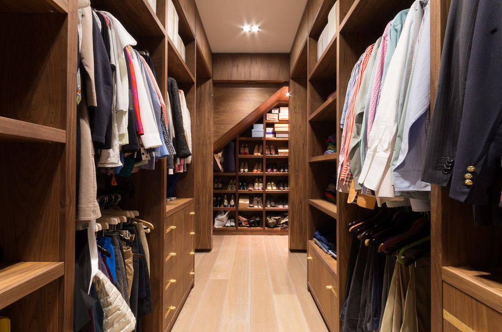 Ejemplo de armario vestidor unisex actual con armarios abiertos, puertas de armario de madera oscura, suelo de madera clara y suelo beige
