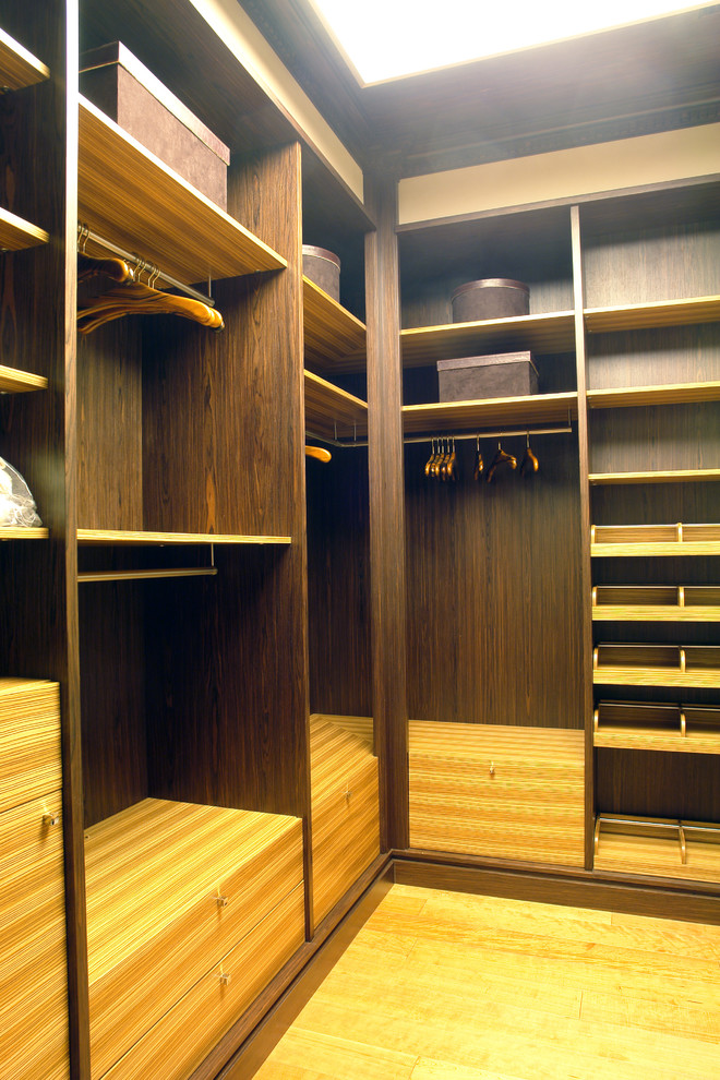 Foto de armario vestidor unisex pequeño con suelo de madera clara y suelo marrón