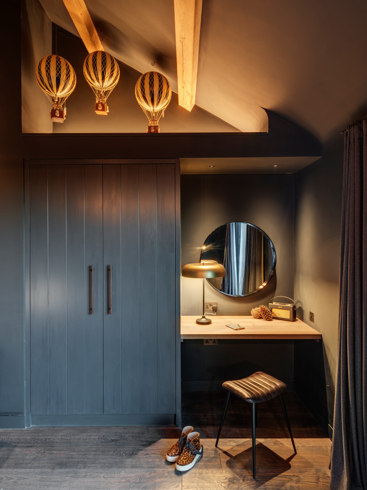 Modernes Ankleidezimmer mit Ankleidebereich, flächenbündigen Schrankfronten, grauen Schränken, dunklem Holzboden, braunem Boden und gewölbter Decke in Cornwall