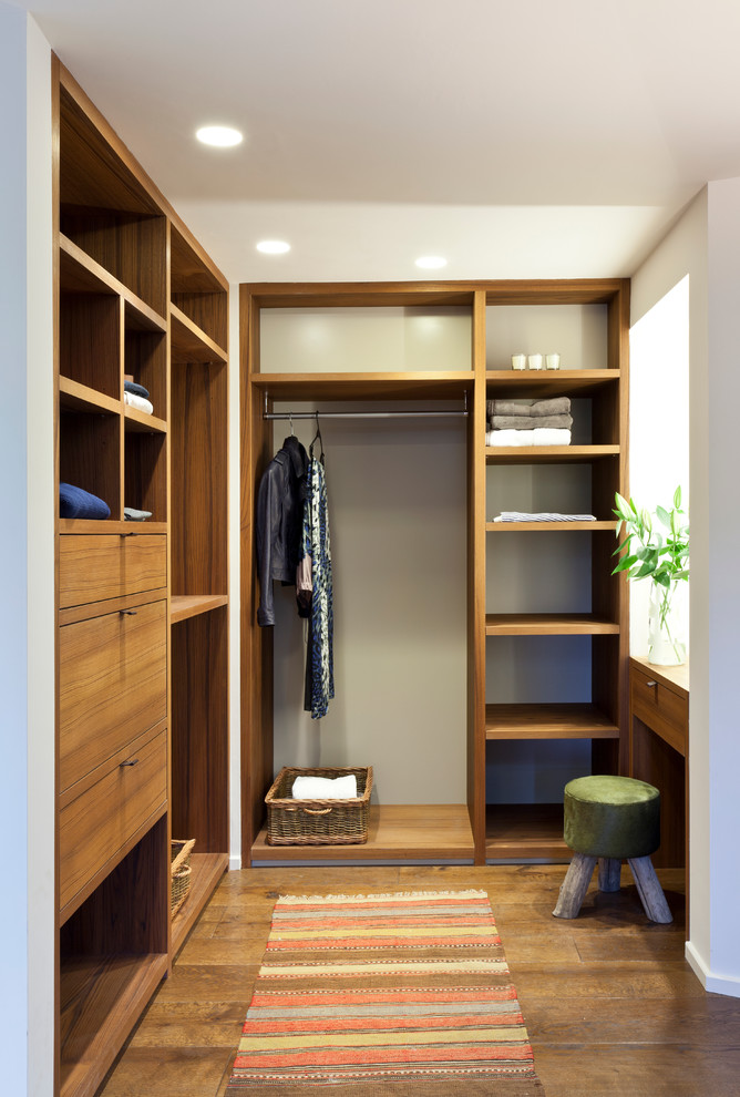 Dressing room - contemporary gender-neutral medium tone wood floor dressing room idea in Gloucestershire with open cabinets and medium tone wood cabinets