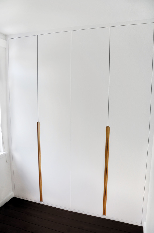 Medium sized contemporary wardrobe in London with dark hardwood flooring.
